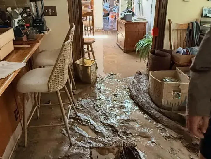 Mud and floodwater spread across a kitchen floor after a flash flood